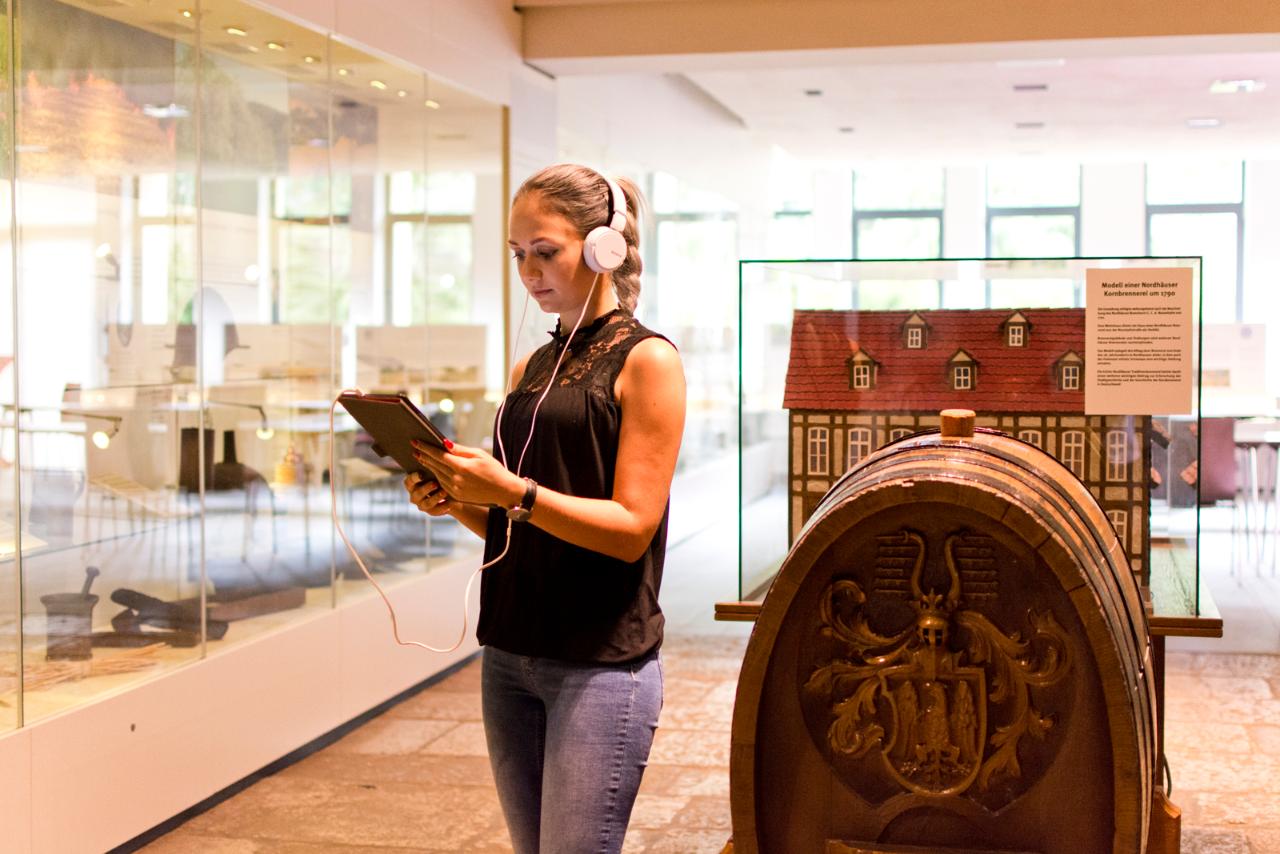 Junge Frau mit Audioguide erkundigt die Nordhäuser Traditionsbrennerei